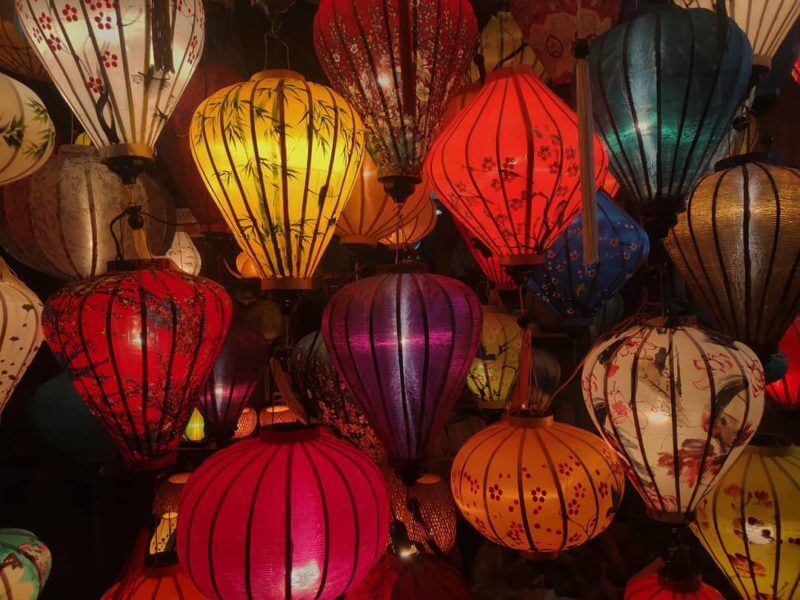 Motivlampions und einfarbige Lampions hängen auf einem Markt in Asien
